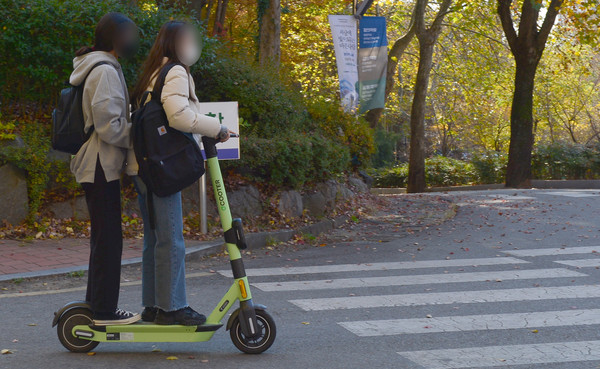 지난 12일 오후 광주 북구 용봉동 한 캠퍼스에서 2명의 이용객이 한 대의 전동 킥보드를 탄 채 달리고 있다. 사진=뉴시스