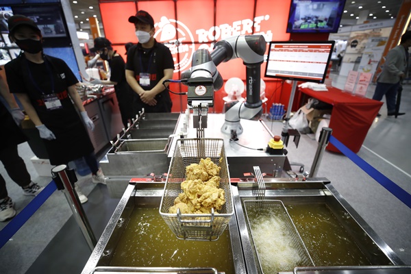 제10회 스마트테크 코리아 및 제1회 디지털 유통대전에서 로봇이 치킨을 튀기고 있다.  사진=뉴시스