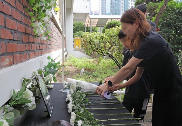서이초 사망 교사 49재를 맞은 4일 오전 서울 서초구 서이초등학교에서보호자와 어린이가 헌화하고 있다. 사진=뉴시스