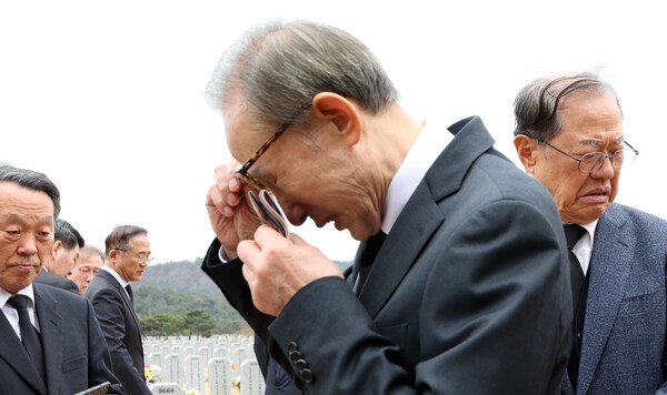 이명박 전 대통령이 25일 대전시 유성구 국립대전현충원 고 한주호 준위의 묘소를 참배한 뒤 눈물을 닦고 있는 모습. 사진=뉴시스
