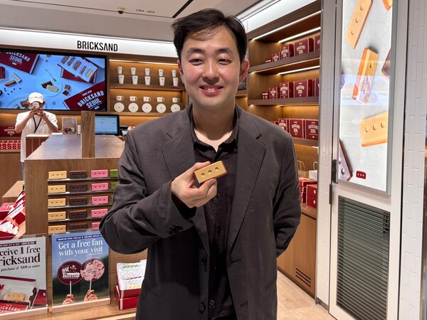 신세계면세점 브릭샌드 매장 앞에서 조헌기 대표가 휘낭시에를 들어보이고 있다. / 사진=김나연 기자