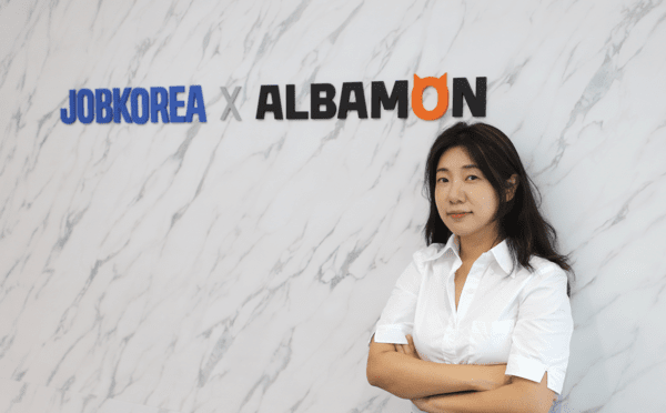 김여름 통합브랜딩팀 팀장이 브랜드 로고 앞에 서 있다.  사진=잡코리아