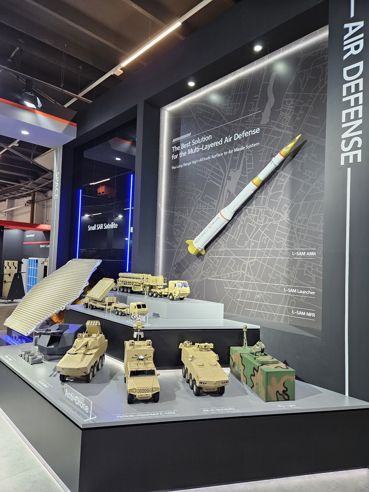  한화시스템의 레이저 대공무기 '천광'(사진 맨앞 맨오른쪽)이 폴란드 키엘체에서 열린 MSPO 2025에 전시돼 있다. 아랫단 왼쪽부터 한화에어로의 40mm 지능형 무인방공시스템과 H-쇼라드, 한화시스템의 기동형 안티드론 솔루션, DE H-쇼라드, 천광. 사진=한화시스템