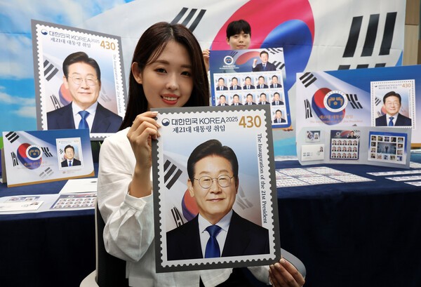 이재명 대통령 기념 우표를 들고 있는 모델. 사진=뉴시스