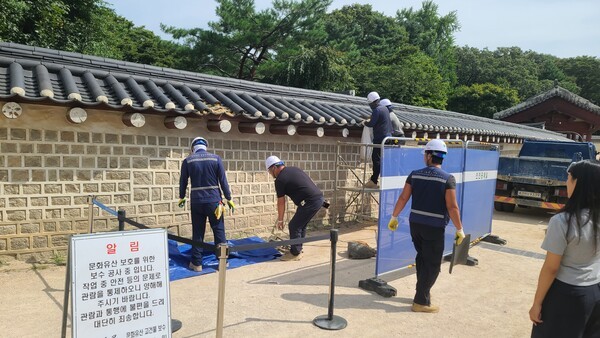 훼손된 종묘 담장을 작업자들이 보수하고 있다. 사진=국가유산청