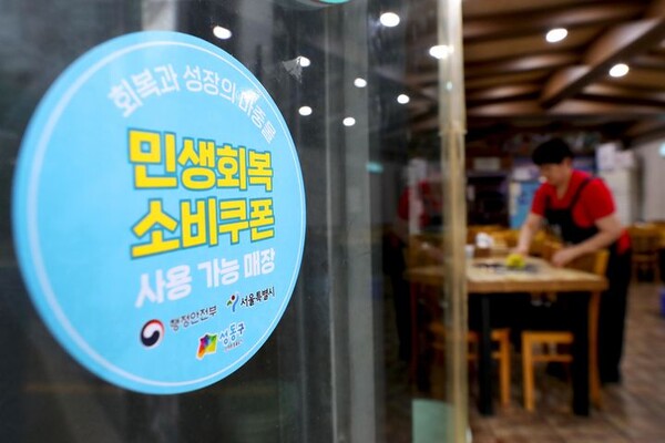 성동구의 한 음식점 출입문에 붙은 민생회복 소비쿠폰 안내문. 사진=성동구