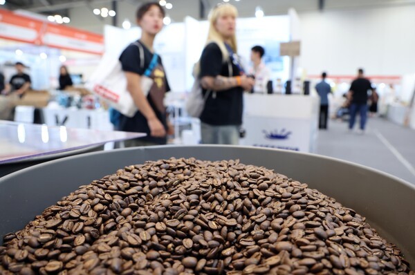 2025 부산카페쇼를 찾은 관람객들이 행사장 내 원두가 쌓여 있는 부스 앞을 지나고 있다. 사진=뉴시스