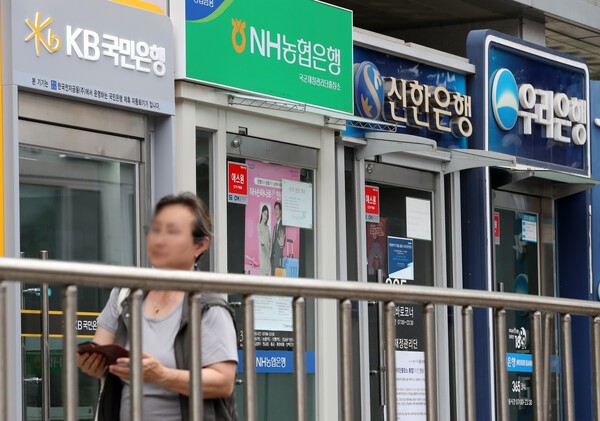 서울의 한 시중은행 ATM기가 몰려 있는 길을 한 시민이 지나가고 있다. 사진=뉴시스